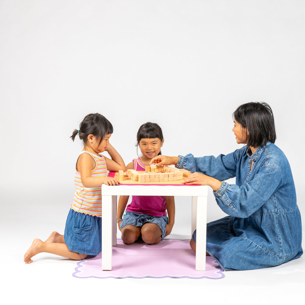 family playing mahjong with wooden tiles