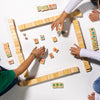 Children playing with wooden mahjong on a white surface