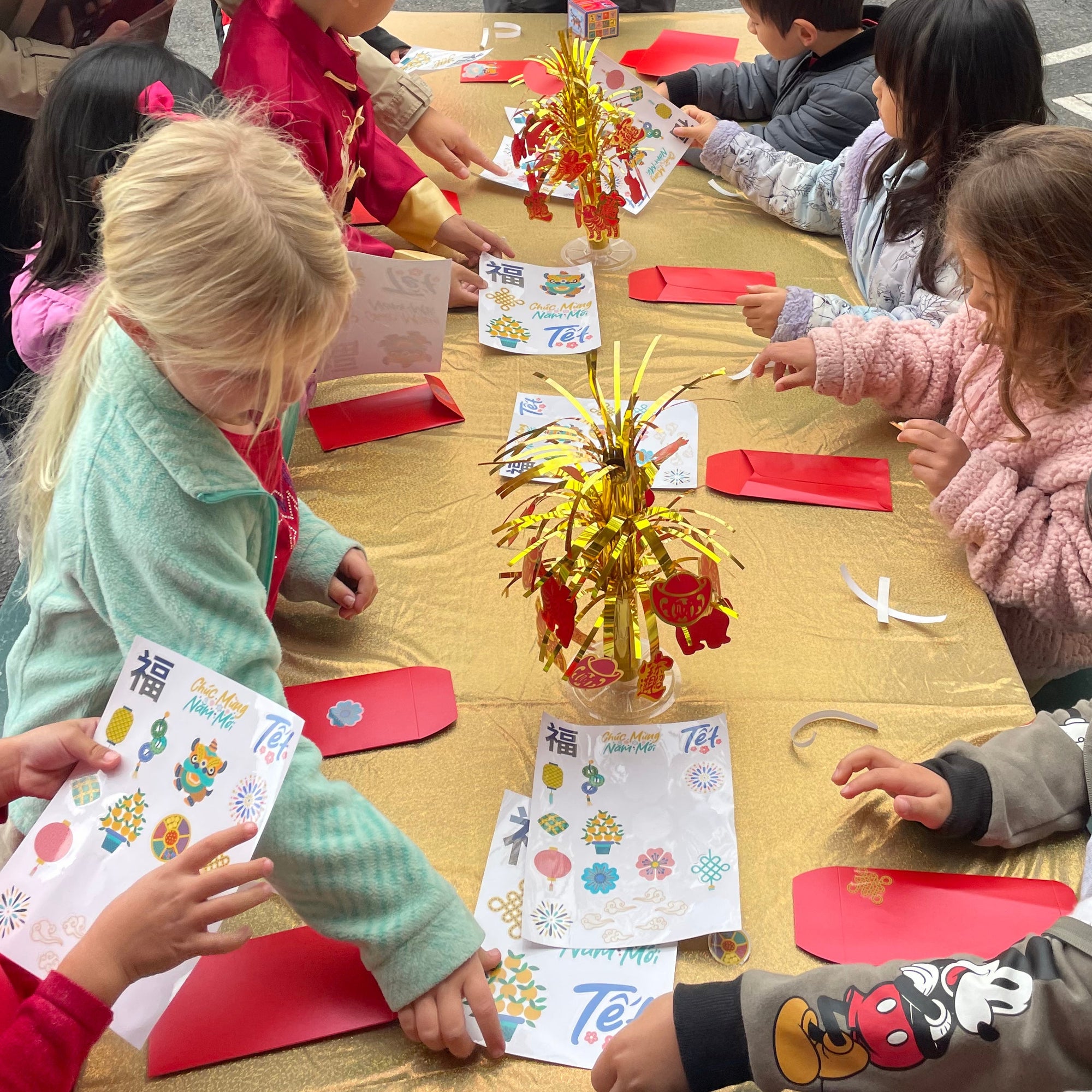 school kids making lucky red envelopes for lunar new year