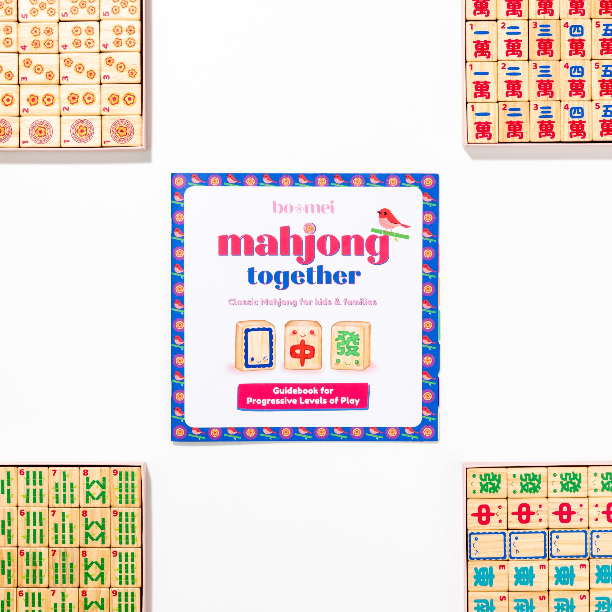 Mahjong Together guidebook surrounded by beautiful mahjong tiles on a white background