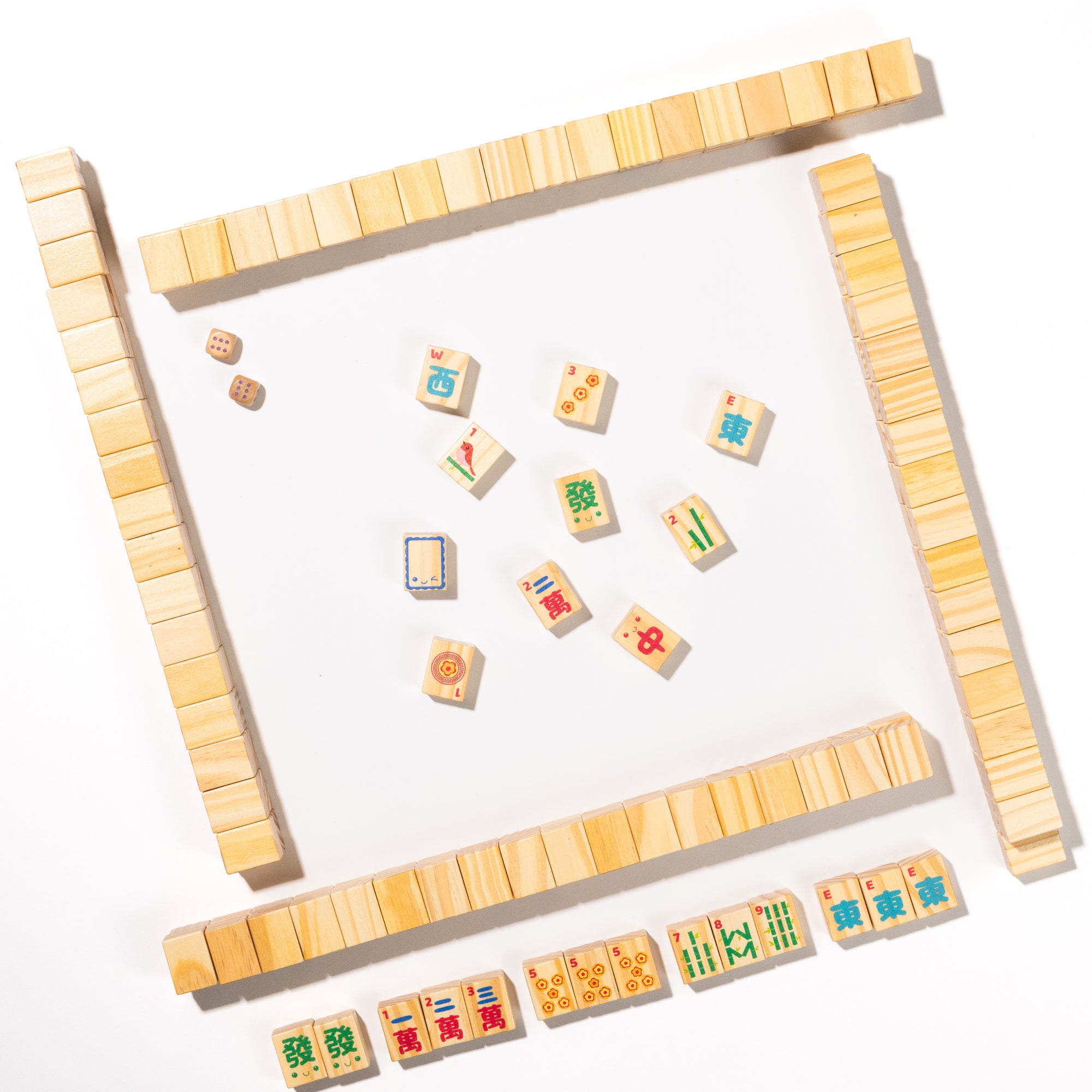 Wooden mahjong tiles with colorful designs on a white background